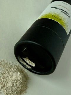 Daily exfoliating powder being poured to show lightweight, airy consistency