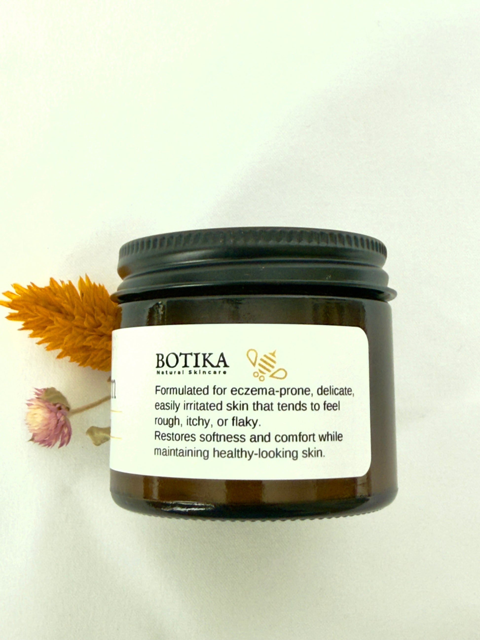 Botika Honey Colloidal Oat Cream for eczema-prone skin jar leaned on white surface — natural face and body cream for eczema-prone and sensitive skin